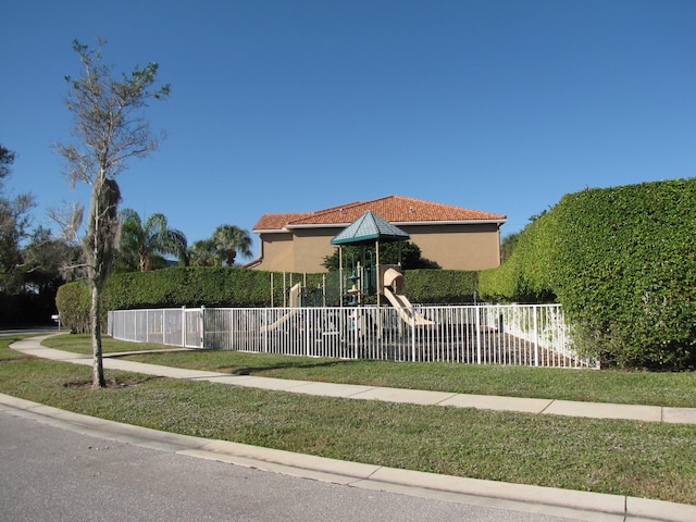 view of front facade featuring a playground and a front lawn