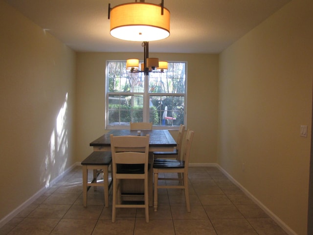 tiled dining area featuring a chandelier