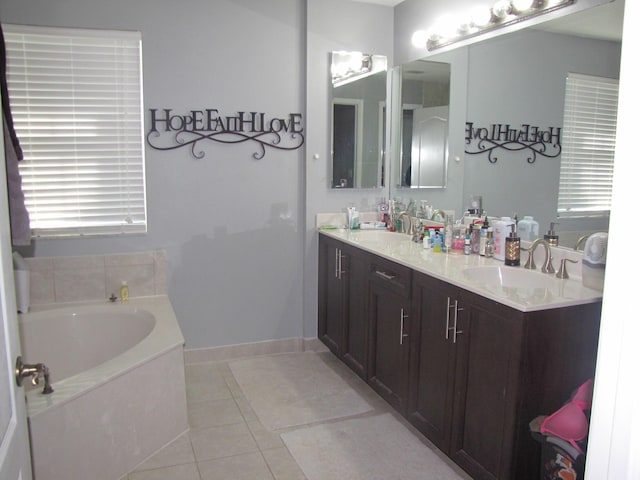 bathroom featuring tile patterned floors, a tub, and vanity