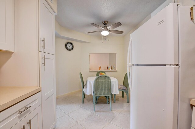 kitchen featuring white cabinets, a textured ceiling, white appliances, and sink