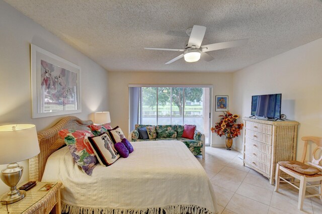 tiled bedroom featuring access to outside, ceiling fan, and a textured ceiling