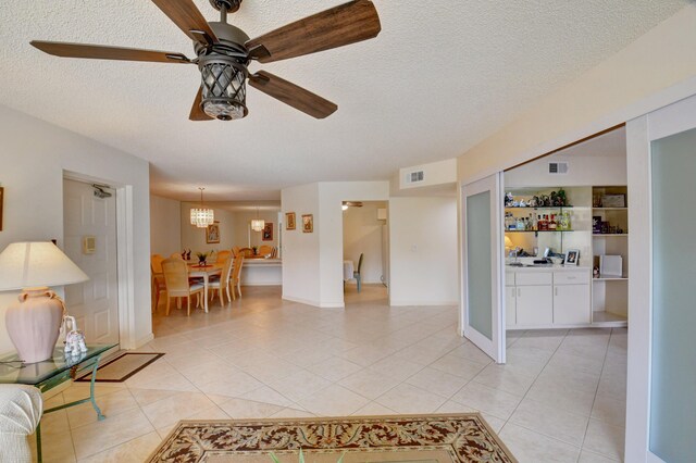 living room featuring light tile patterned floors, a textured ceiling, and ceiling fan