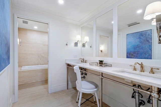 bathroom with a bathing tub, vanity, and crown molding