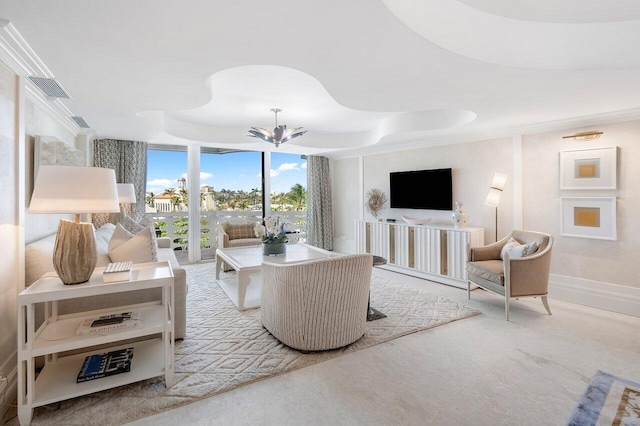 living room with a notable chandelier and a tray ceiling