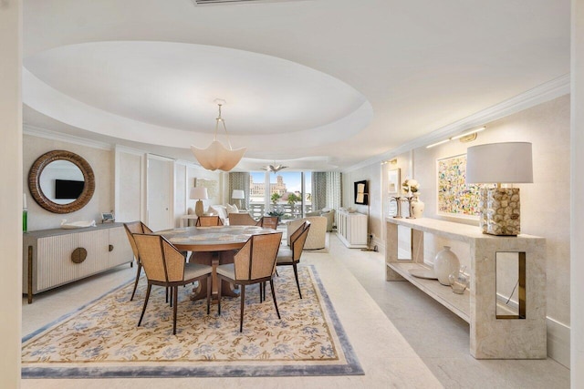 dining space featuring a raised ceiling, crown molding, and a chandelier