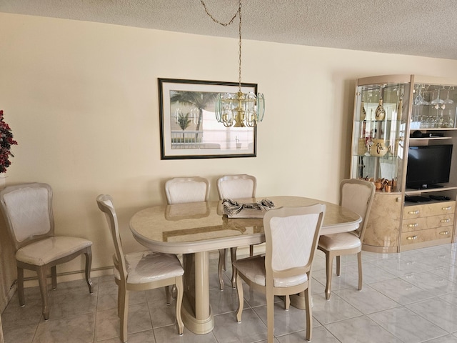 tiled dining space with a textured ceiling and a chandelier