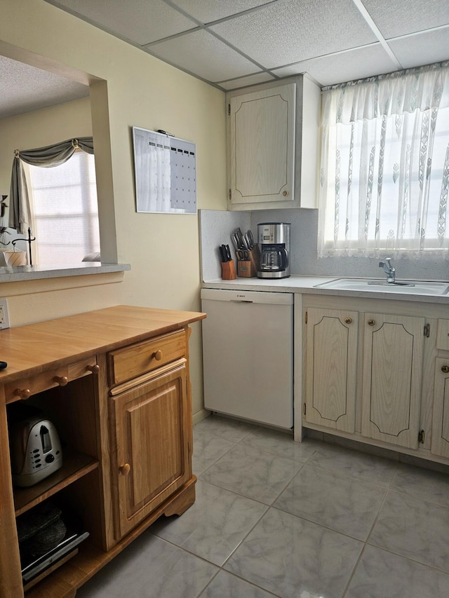 kitchen featuring white dishwasher, a paneled ceiling, butcher block counters, and sink