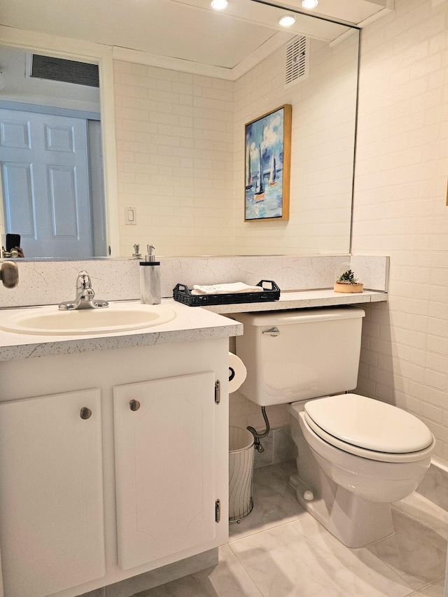 bathroom featuring vanity, tile walls, and toilet