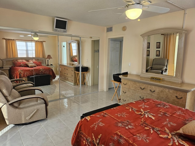 tiled bedroom with a textured ceiling, a closet, and ceiling fan