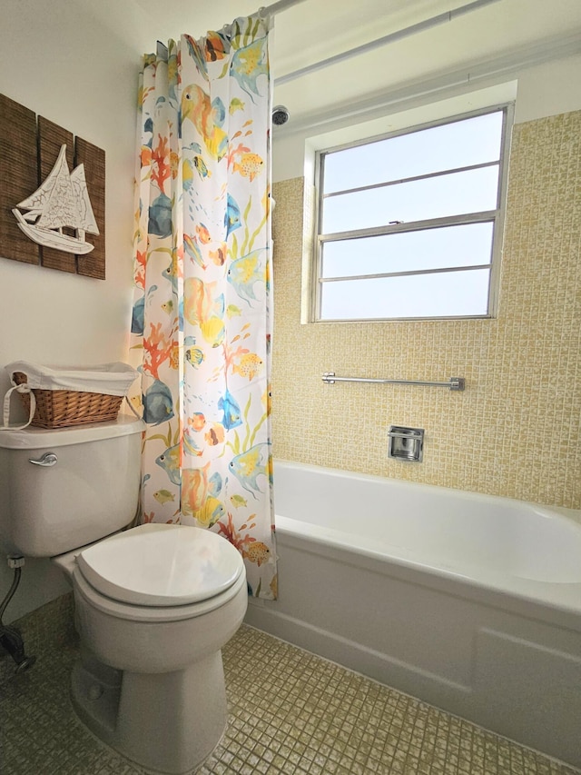 bathroom featuring shower / bath combo with shower curtain and toilet