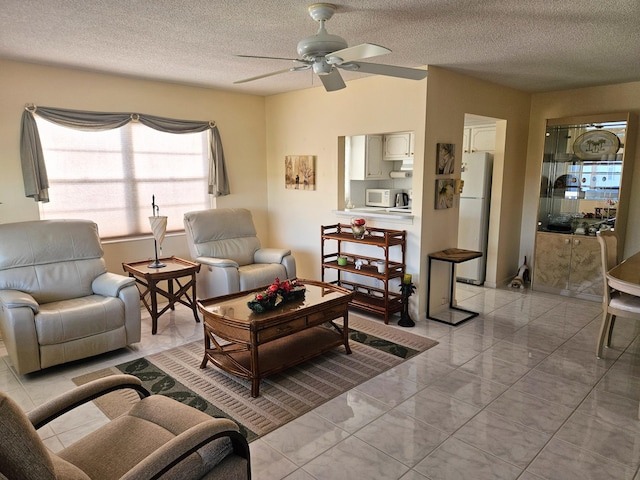 living room featuring ceiling fan and a textured ceiling