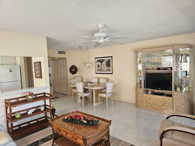 living room featuring a textured ceiling and ceiling fan