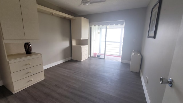 unfurnished room with ceiling fan, dark hardwood / wood-style flooring, and a textured ceiling