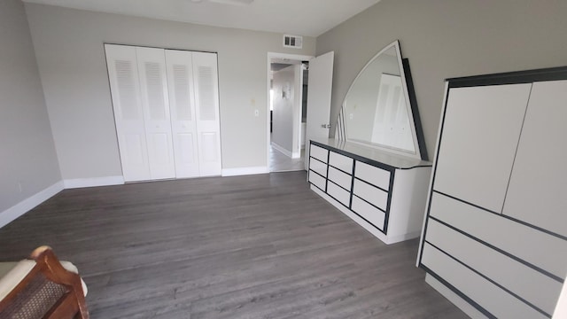 unfurnished bedroom with a closet and dark wood-type flooring