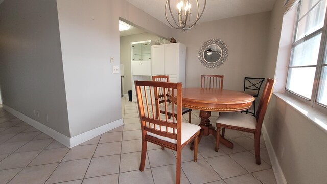 dining area featuring light tile patterned floors, a wealth of natural light, and an inviting chandelier