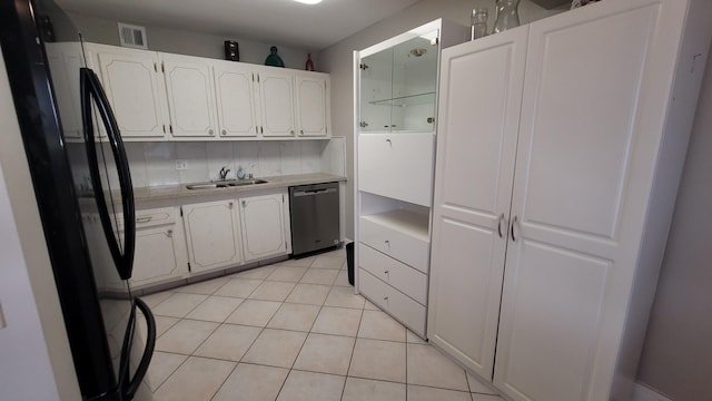 kitchen with dishwasher, sink, light tile patterned flooring, fridge, and white cabinets