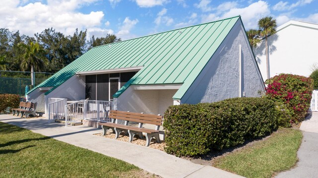2400 S Ocean Dr Unit 6523, Fort Pierce, FL 34949 - exterior space featuring metal roof, a sunroom, a lawn, and a standing seam roof