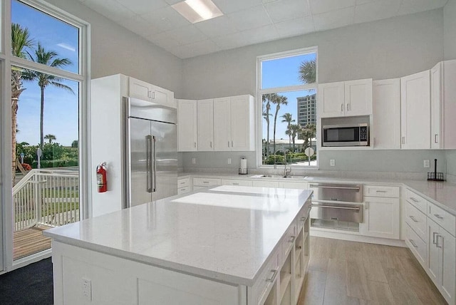 2400 S Ocean Dr Unit 6523, Fort Pierce, FL 34949 - kitchen with a kitchen island, a sink, white cabinets, light wood-style floors, and built in appliances