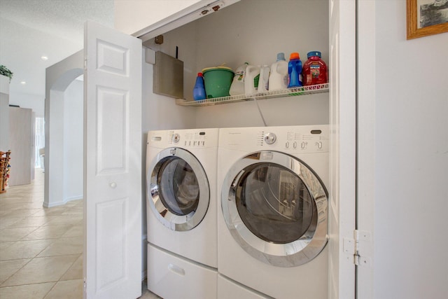 clothes washing area with light tile patterned flooring and washer and dryer