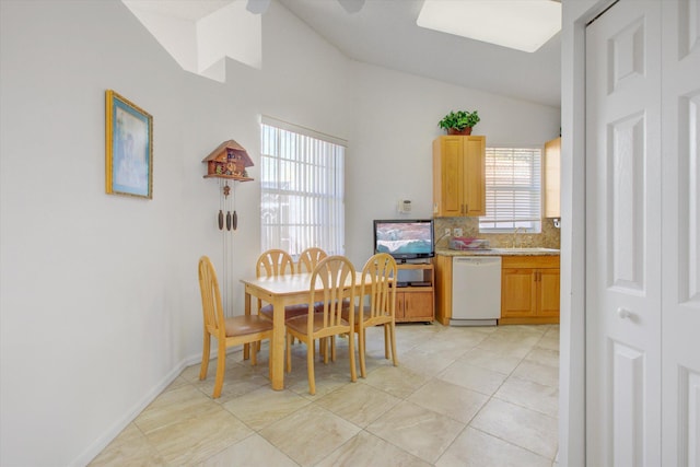 dining area with sink, light tile patterned floors, and vaulted ceiling