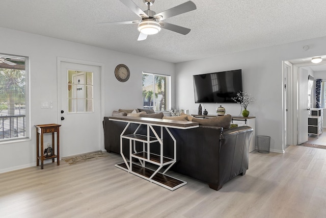 living room with ceiling fan, wood-type flooring, and a textured ceiling