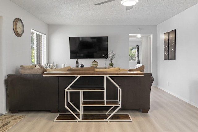 living room featuring ceiling fan, a textured ceiling, and hardwood / wood-style flooring