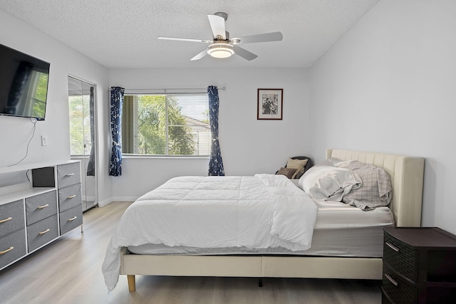 bedroom featuring ceiling fan, a textured ceiling, and light hardwood / wood-style flooring