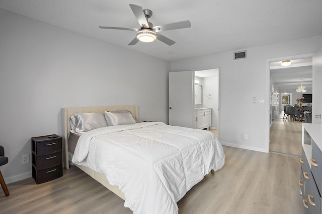 bedroom with ceiling fan, a textured ceiling, and light hardwood / wood-style flooring