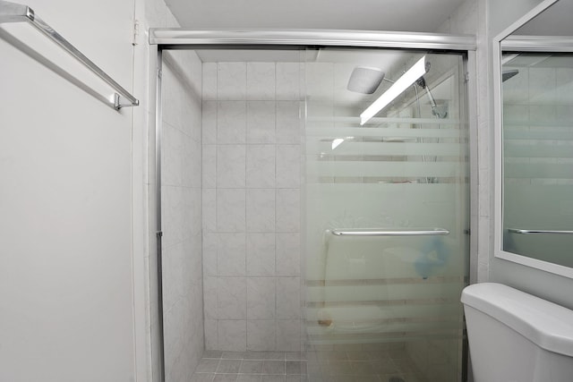 bathroom with walk in shower, tile patterned floors, and toilet