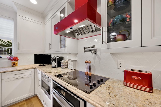 kitchen with white cabinets, stainless steel appliances, and wall chimney exhaust hood