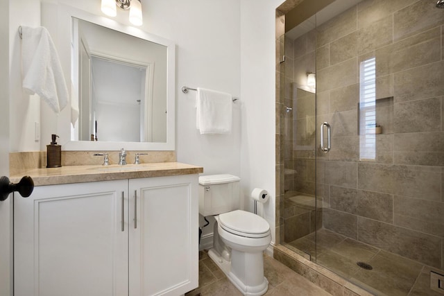 bathroom featuring tile patterned flooring, vanity, toilet, and a shower with shower door