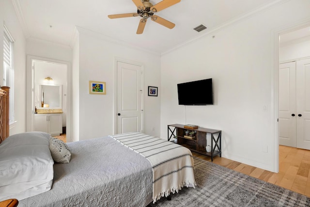 bedroom with ensuite bathroom, ceiling fan, ornamental molding, wood-type flooring, and a closet