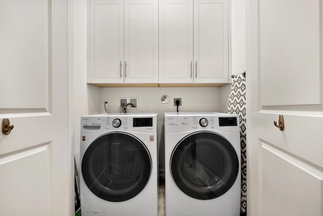 washroom featuring cabinets and washing machine and clothes dryer