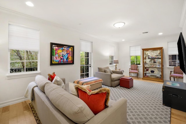 living room with light wood-type flooring and ornamental molding