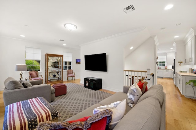 living room featuring light hardwood / wood-style floors and ornamental molding