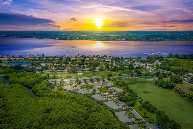 aerial view at dusk featuring a water view