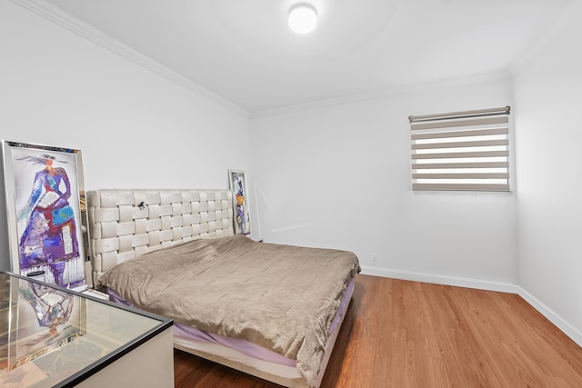 bedroom with hardwood / wood-style flooring and ornamental molding