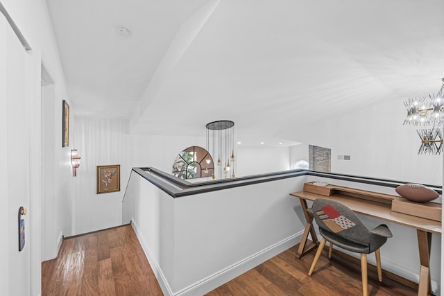 interior space with hardwood / wood-style floors, lofted ceiling, and an inviting chandelier