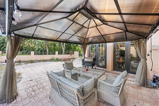 view of patio featuring french doors, area for grilling, and a gazebo