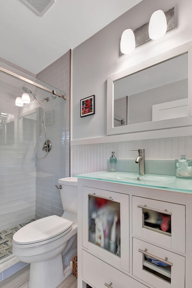 bathroom with vanity, a shower with shower door, and toilet