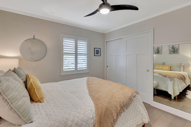 bedroom with a closet, ceiling fan, light hardwood / wood-style flooring, and crown molding