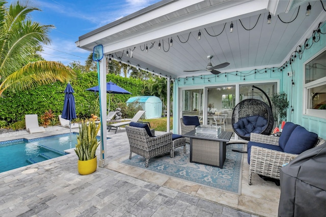 view of patio / terrace with an outdoor living space, ceiling fan, and a storage shed