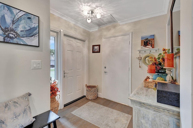 foyer entrance with light hardwood / wood-style flooring and ornamental molding