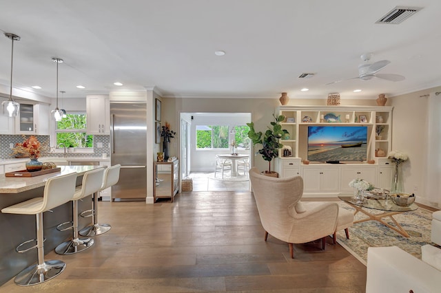 living room with ornamental molding, ceiling fan, dark wood-type flooring, and sink