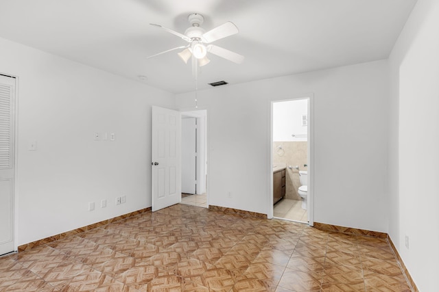 unfurnished bedroom with ensuite bathroom, light parquet floors, and ceiling fan