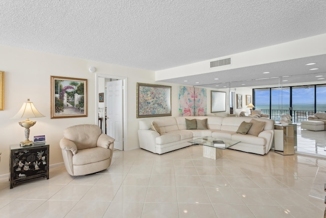 tiled living room with expansive windows and a textured ceiling