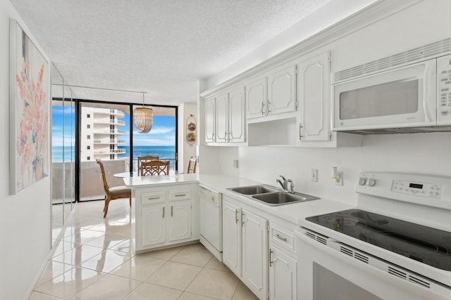 kitchen featuring white appliances, white cabinets, sink, a textured ceiling, and kitchen peninsula