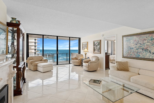 living room featuring expansive windows, a water view, a healthy amount of sunlight, and a textured ceiling