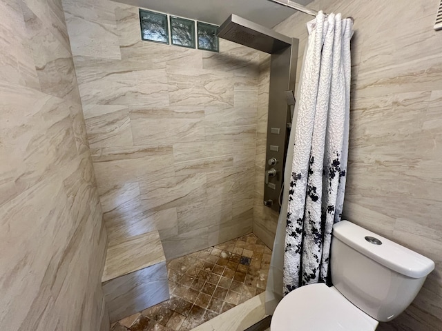 full bathroom featuring toilet and tiled shower