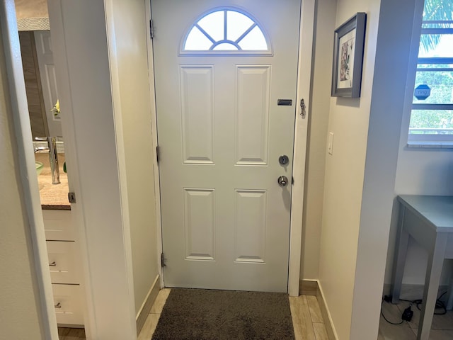 doorway to outside featuring baseboards